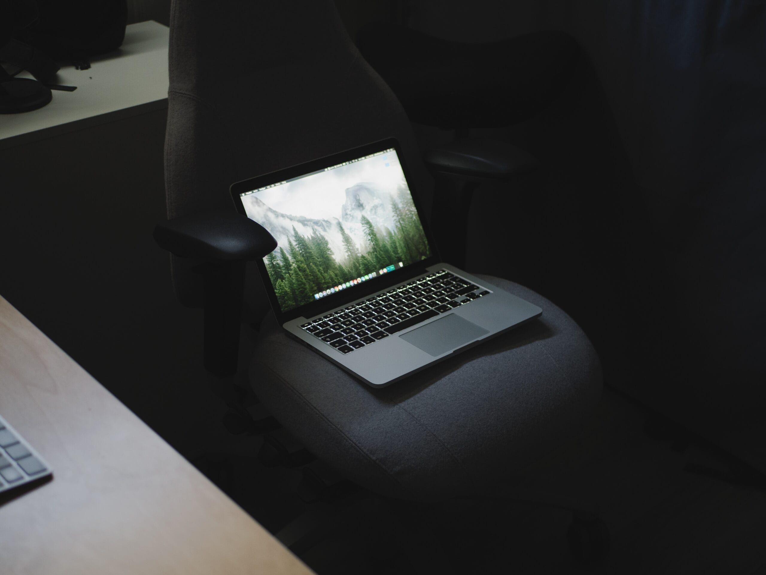 turned on MacBook Pro on office rolling chair