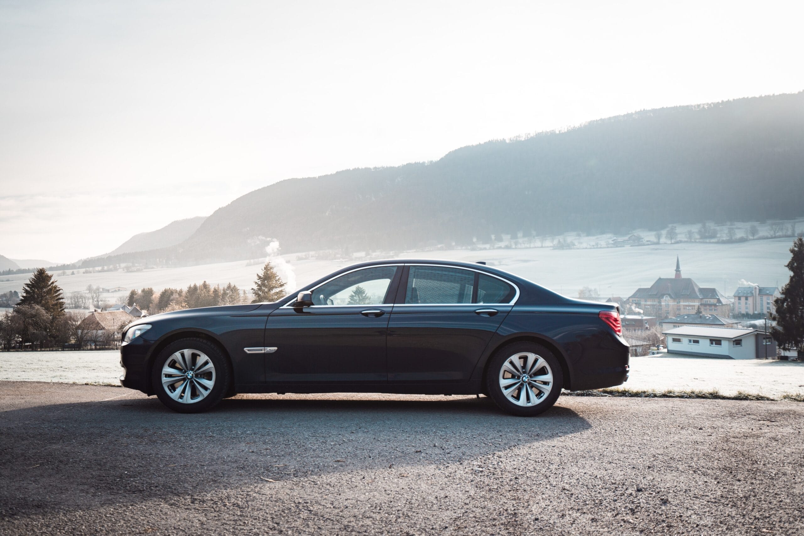 blue sedan on gray asphalt road during daytime